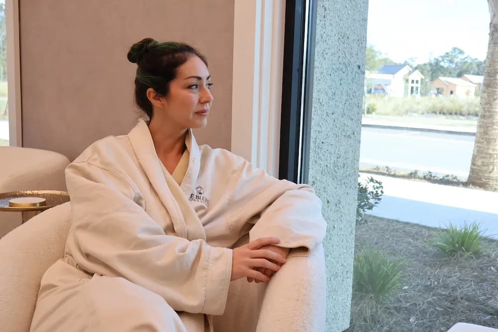Client in a Bluffs robe relaxing in the lounge by the window